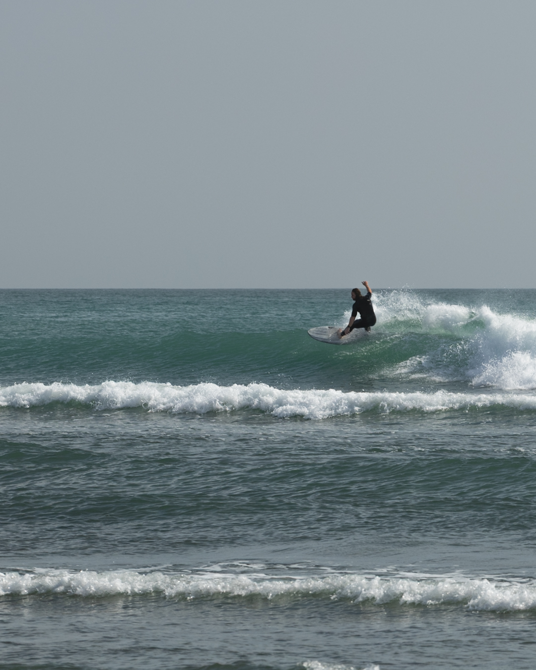 Siôn surfing on a small wave